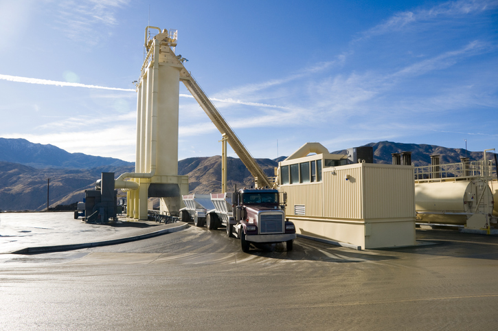 An asphalt manufacturing plant loads asphalt onto a truck for distribution.