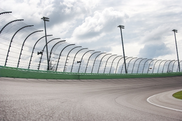 An asphalt paved race track is empty and ready to keep drivers safe.