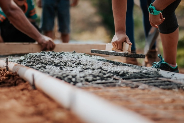 A group of paving professionals lines up an area to fill in concrete. The workers collaborate during the summer months to avoid the problems winter presents for paving projects.